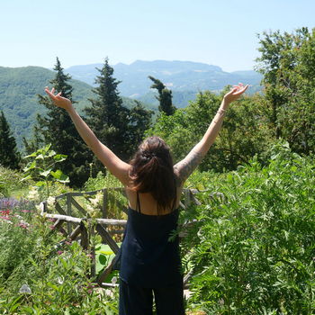 donna a braccia aperte verso il cielo